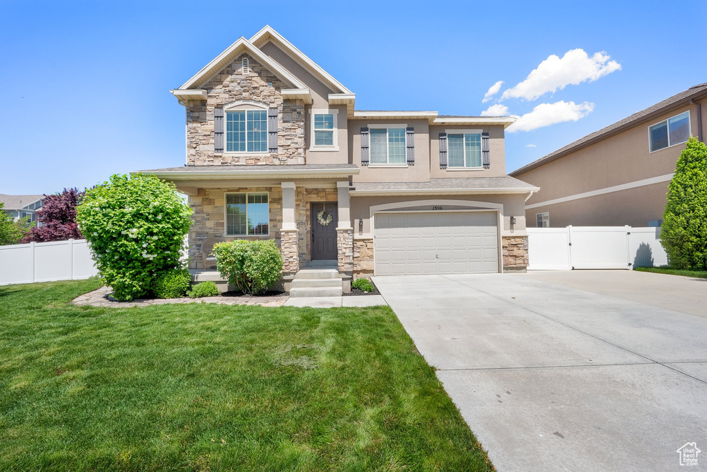 Craftsman-style house featuring stone siding, an attached garage, stucco siding, concrete driveway, and a gate