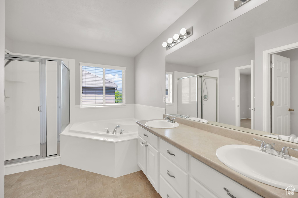 Full bathroom featuring a shower stall, a garden tub, and double vanity
