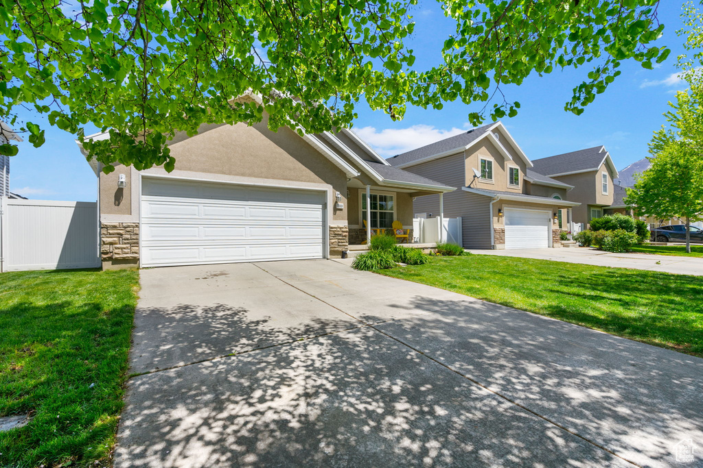 Traditional home featuring stone siding, driveway, and an attached garage