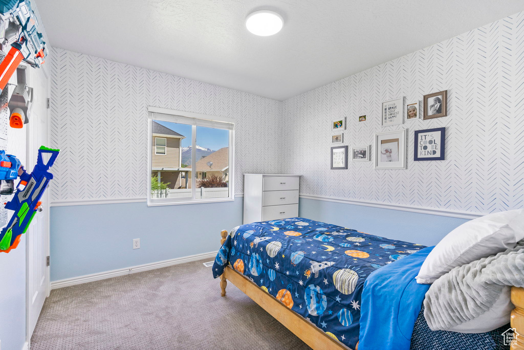 Carpeted bedroom with wallpapered walls and baseboards
