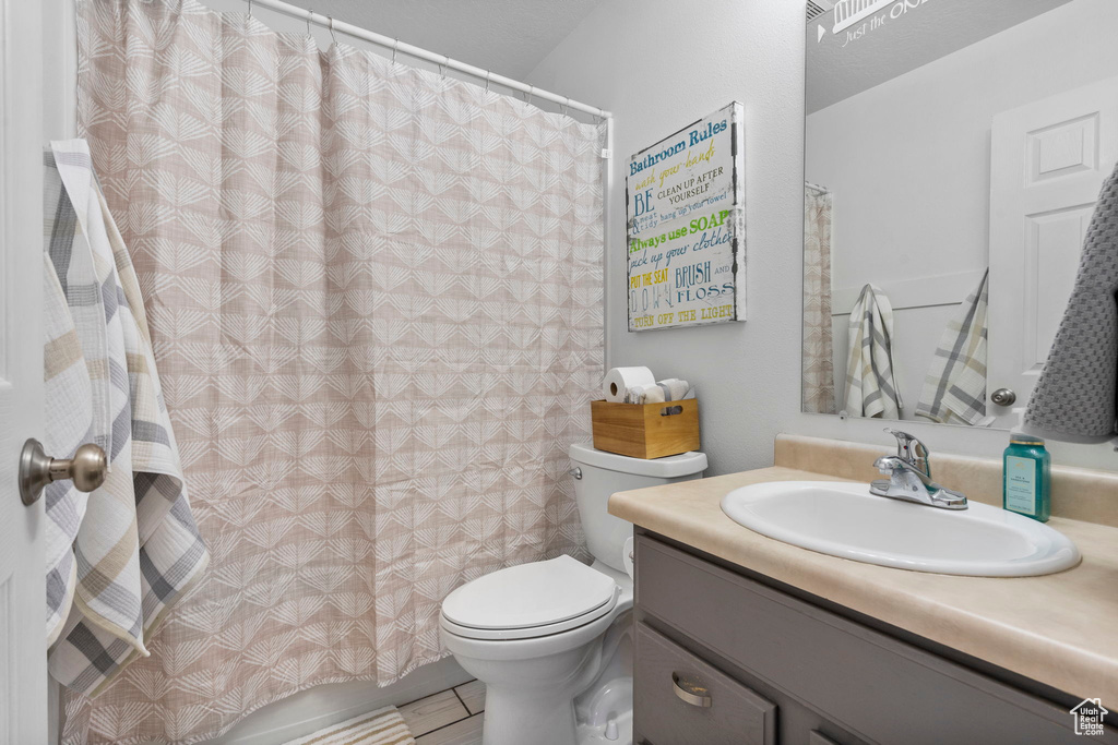 Full bathroom featuring toilet, vanity, and tile patterned floors