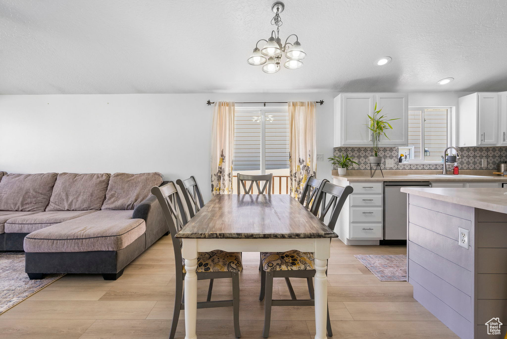 Dining space featuring a chandelier, light wood-type flooring, and recessed lighting