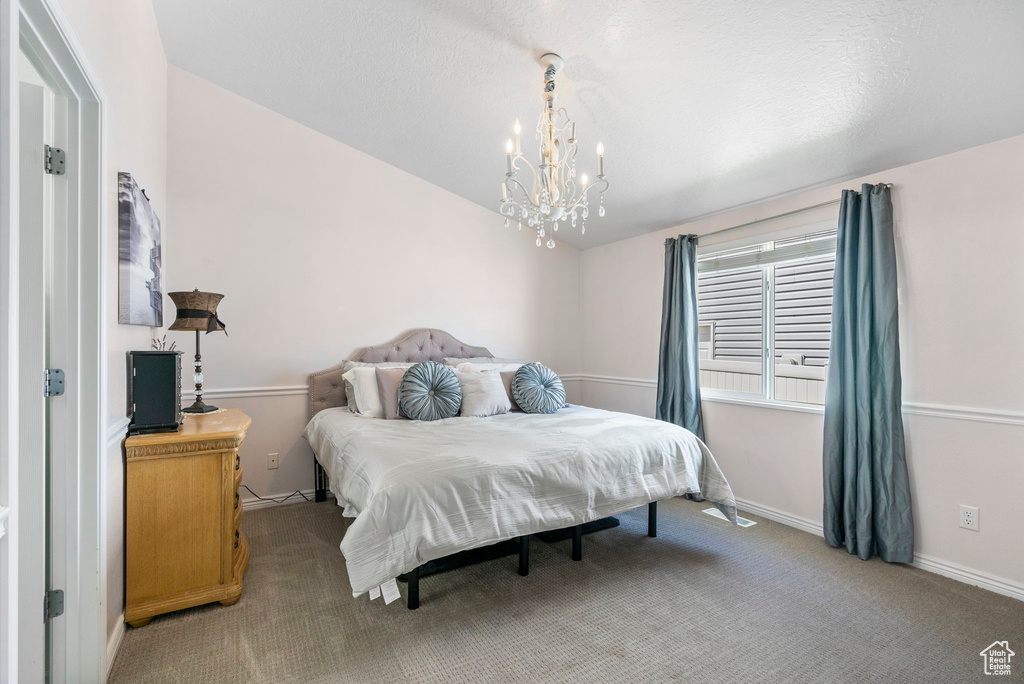 Bedroom featuring a chandelier, carpet flooring, and baseboards