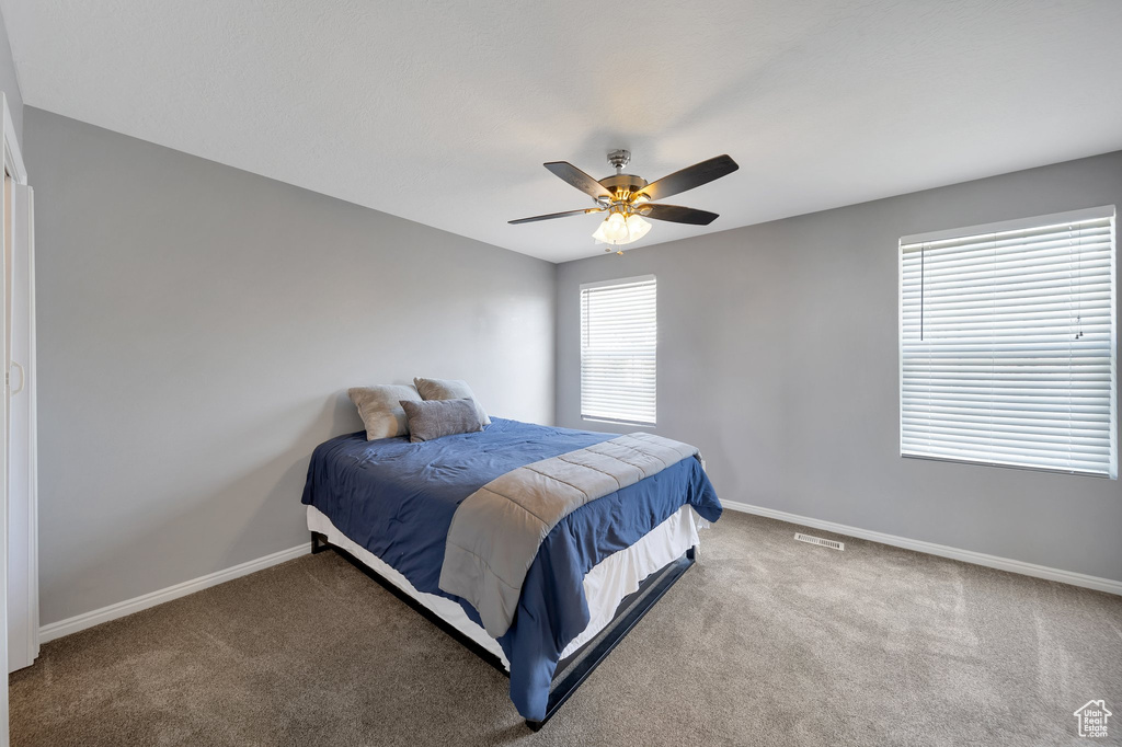 Bedroom with baseboards, carpet floors, and ceiling fan