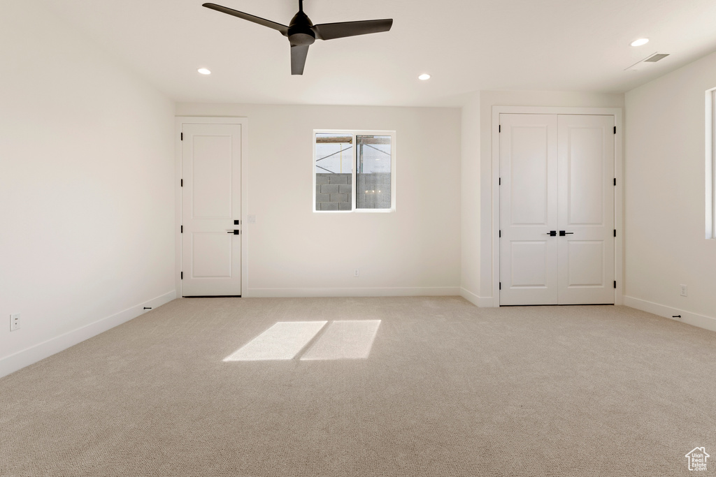 Empty room featuring light carpet, recessed lighting, baseboards, and a ceiling fan