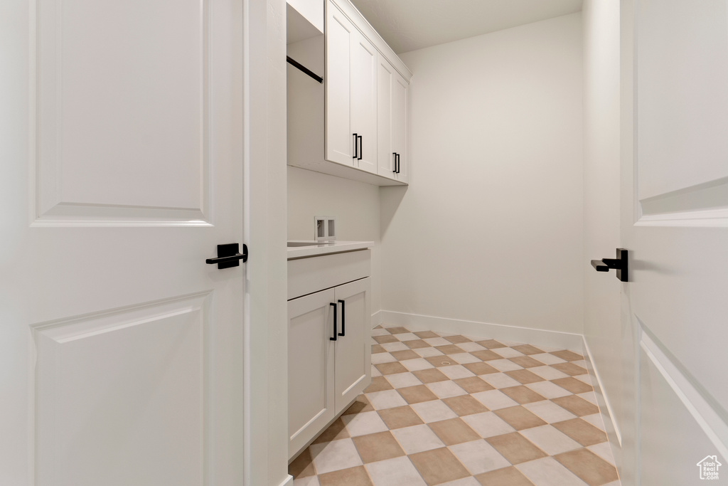Washroom featuring cabinet space, hookup for a washing machine, and baseboards