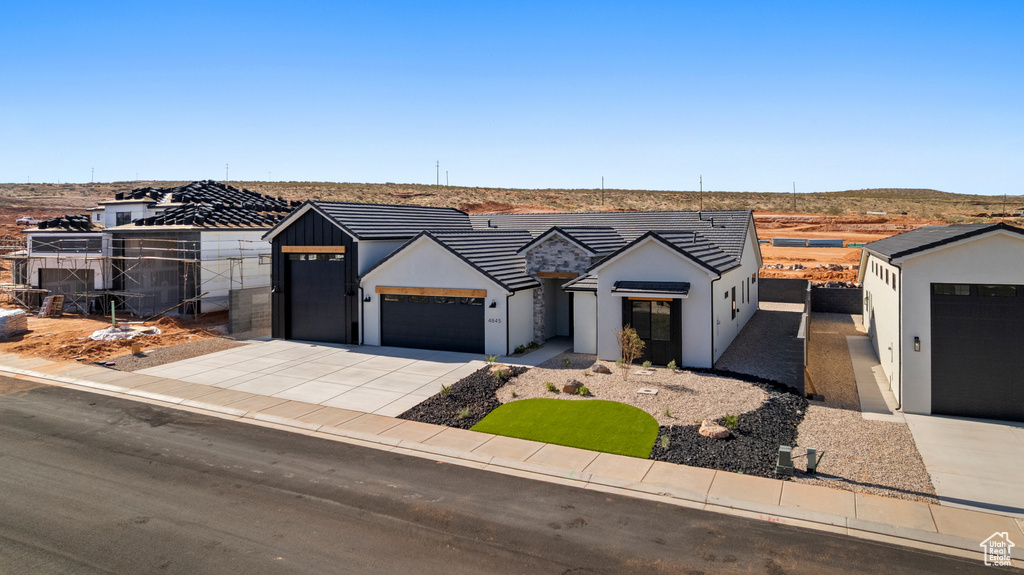 Modern farmhouse style home featuring an attached garage, concrete driveway, and stucco siding