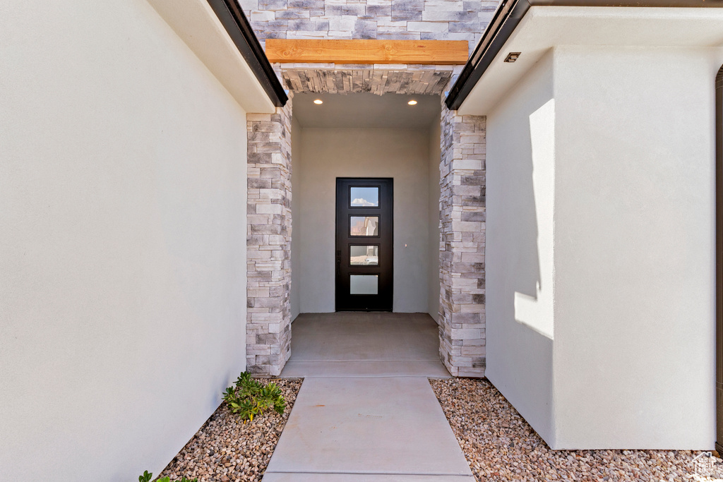Doorway to property with stone siding and stucco siding