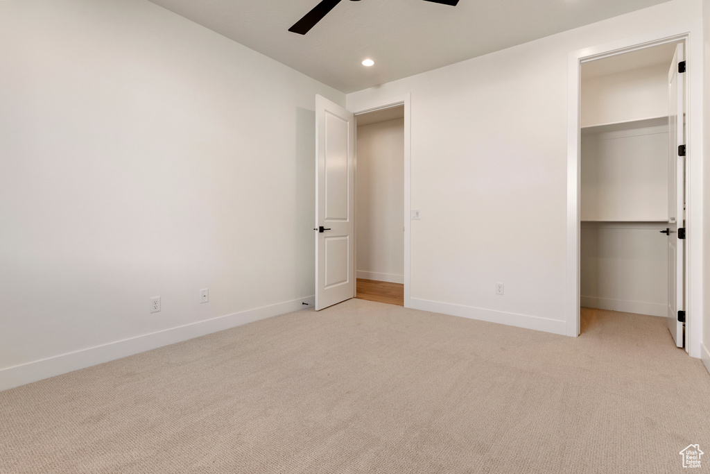 Unfurnished bedroom with recessed lighting, light colored carpet, baseboards, ceiling fan, and a closet