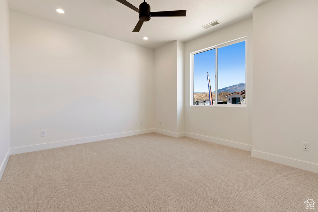 Carpeted spare room featuring baseboards, a ceiling fan, and recessed lighting
