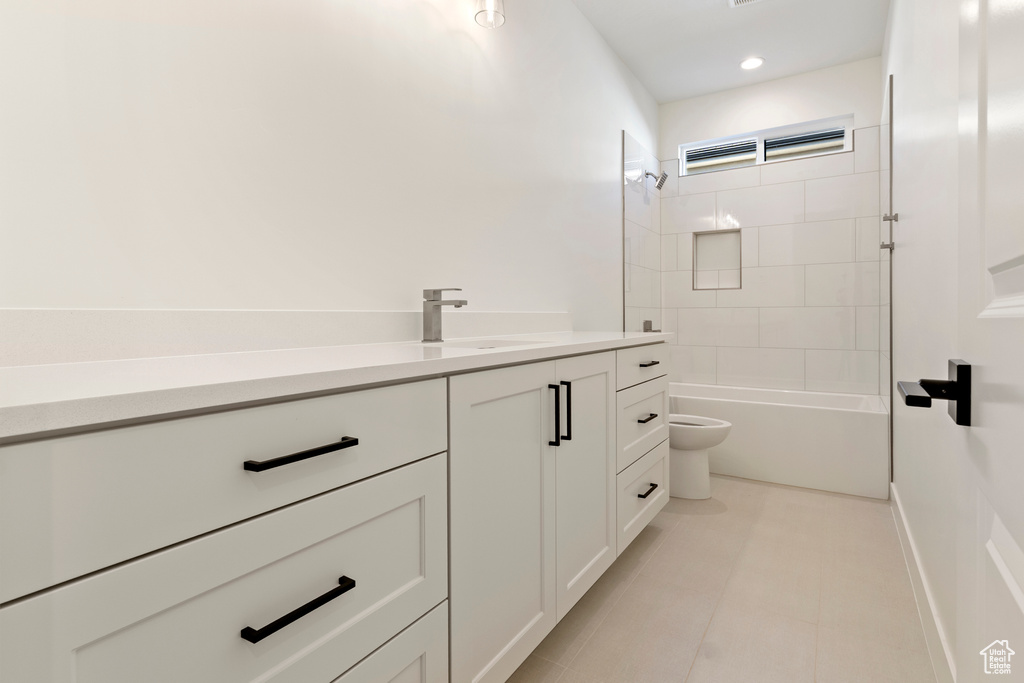 Bathroom with toilet, vanity, shower / tub combination, and tile patterned flooring
