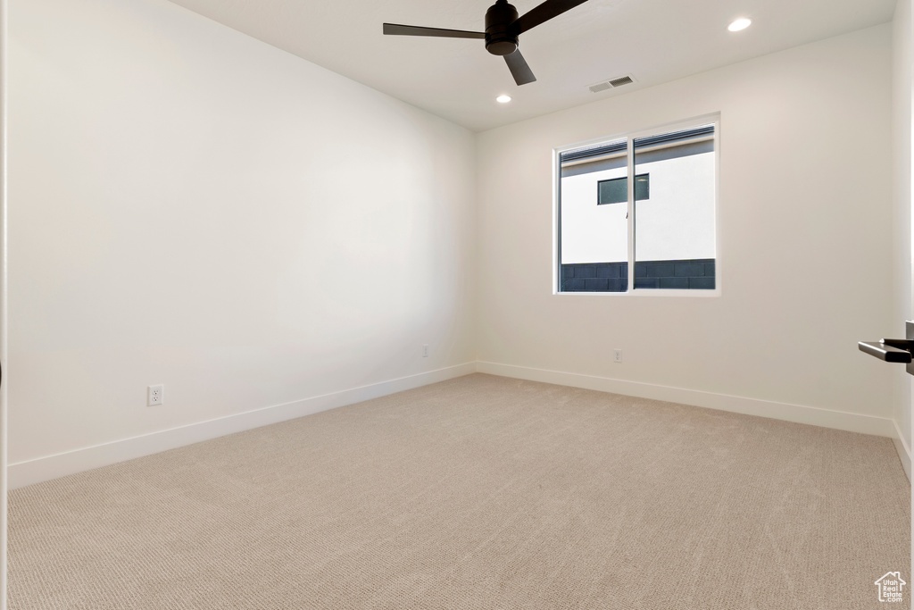 Carpeted spare room featuring ceiling fan, recessed lighting, and baseboards