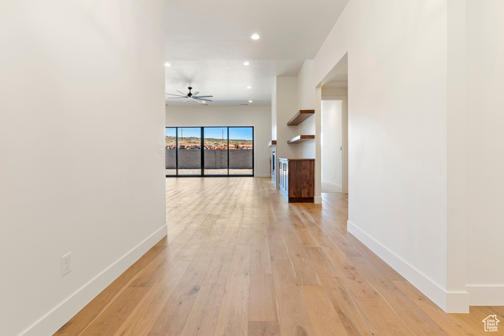 Hall with baseboards, light wood-type flooring, and recessed lighting