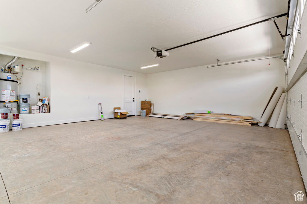 Garage featuring secured water heater and a garage door opener