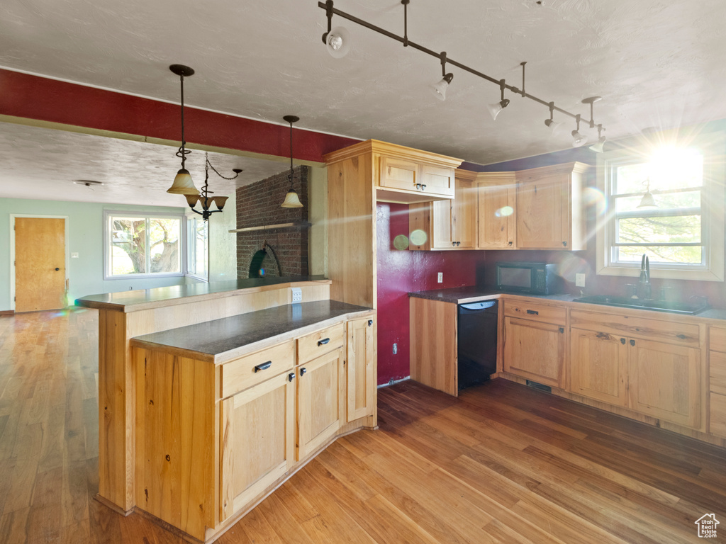 Kitchen with black appliances, light wood-style flooring, a sink, and light brown cabinetry