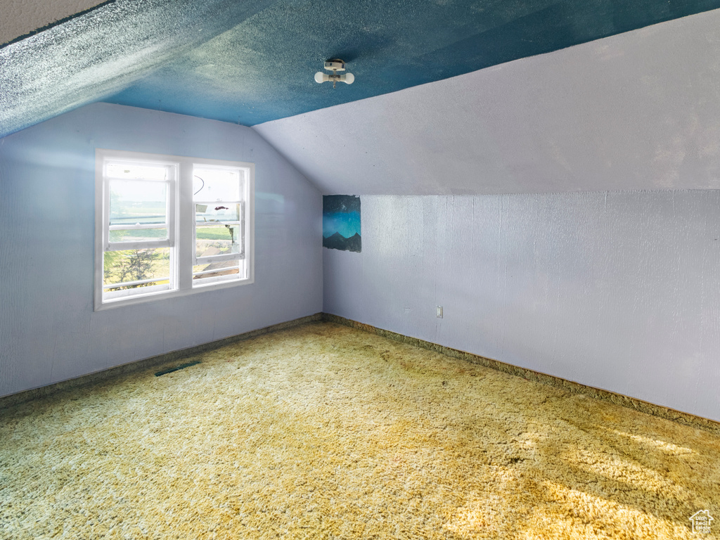 Additional living space featuring lofted ceiling and a textured ceiling