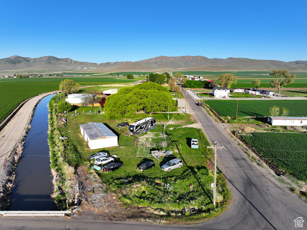 Aerial view of property and surrounding area featuring rural landscape and a water and mountain view