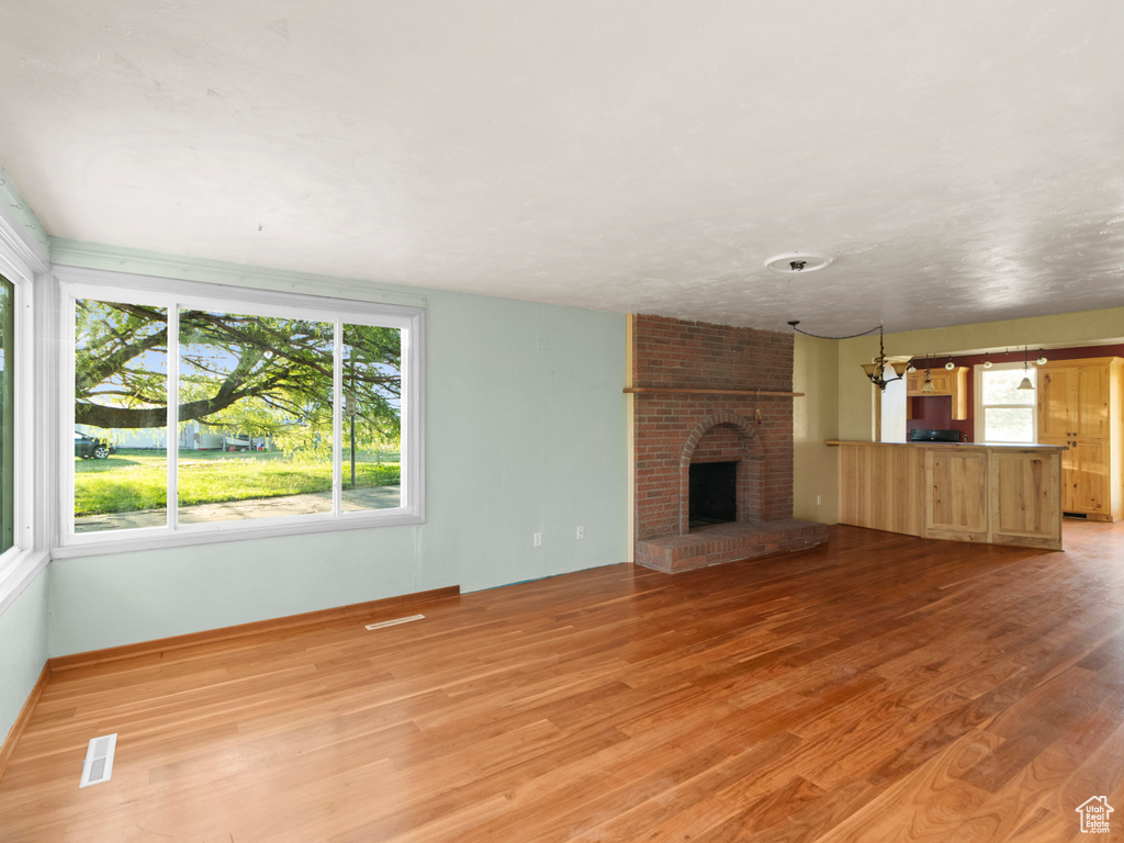 Unfurnished living room featuring light wood-type flooring and a fireplace