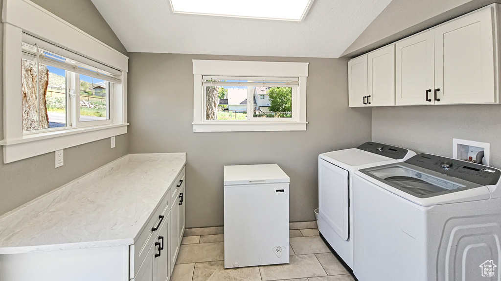 Laundry room featuring cabinet space, separate washer and dryer, and plenty of natural light