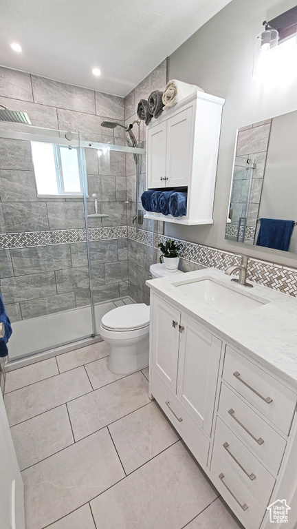 Full bathroom with tile patterned flooring, toilet, a stall shower, and vanity