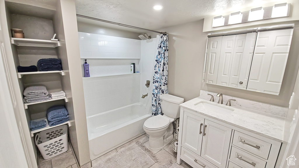 Full bath featuring toilet, vanity, shower / tub combo with curtain, and tile patterned flooring