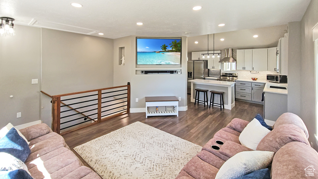Living area with attic access, dark wood finished floors, recessed lighting, and baseboards