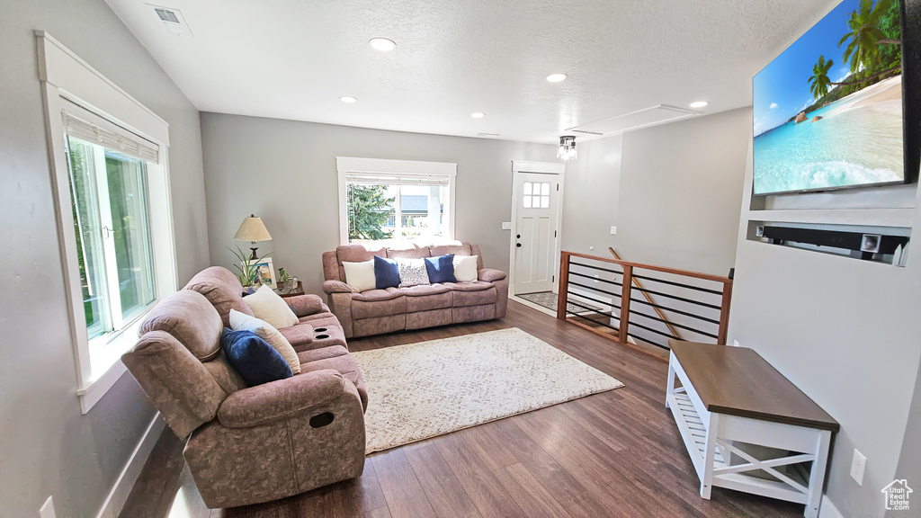 Living area with attic access, wood finished floors, recessed lighting, and a textured ceiling