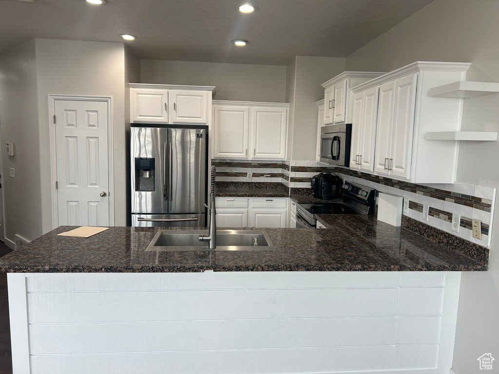 Kitchen featuring appliances with stainless steel finishes, open shelves, decorative backsplash, white cabinetry, and recessed lighting