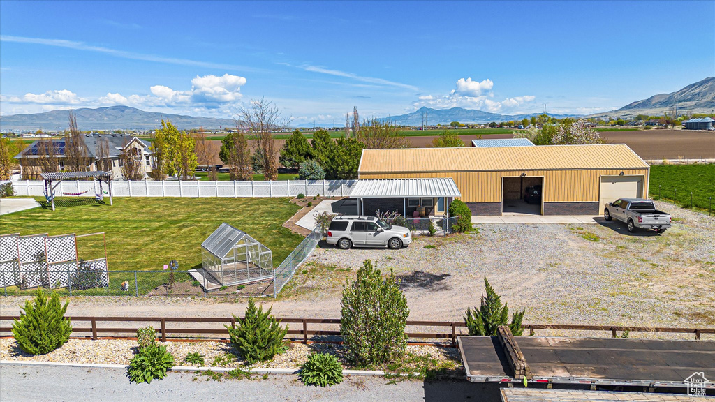 View of yard with a mountain view, gravel driveway, and an attached garage
