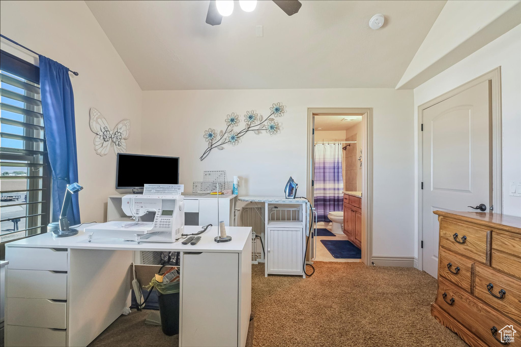 Office space with lofted ceiling, carpet flooring, and a ceiling fan