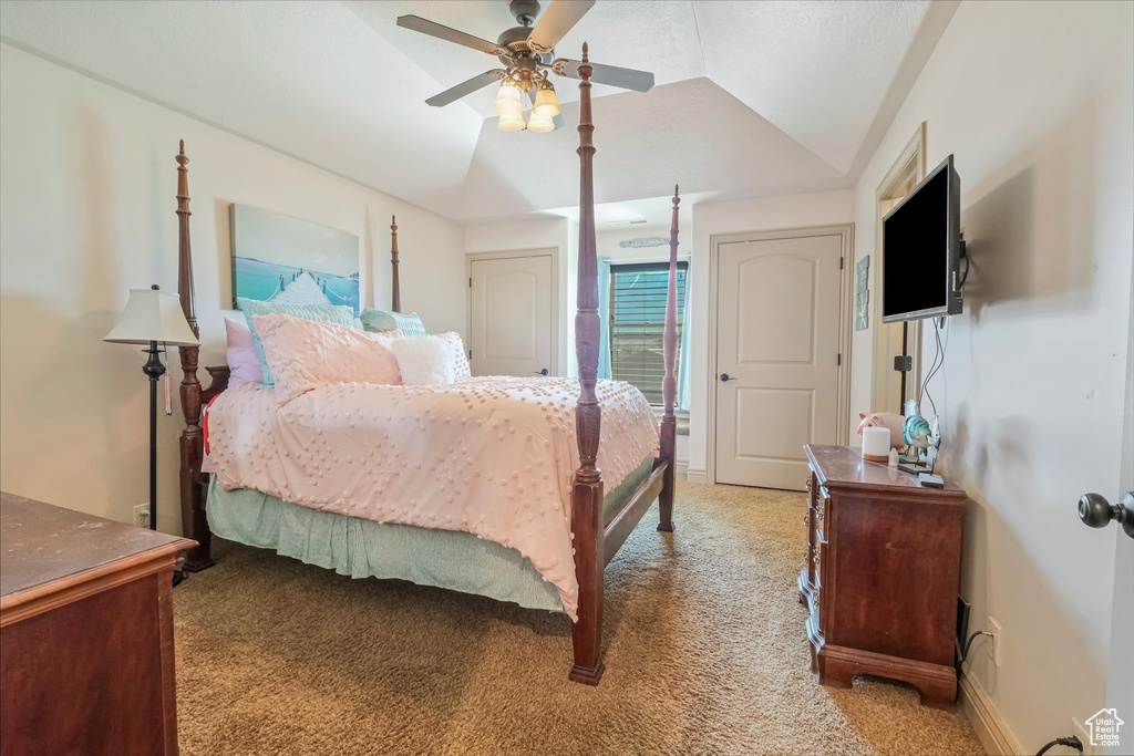 Bedroom with light colored carpet, lofted ceiling, and ceiling fan