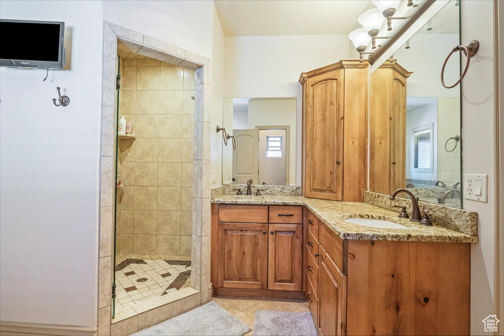 Full bathroom featuring a shower stall, tile patterned flooring, and double vanity
