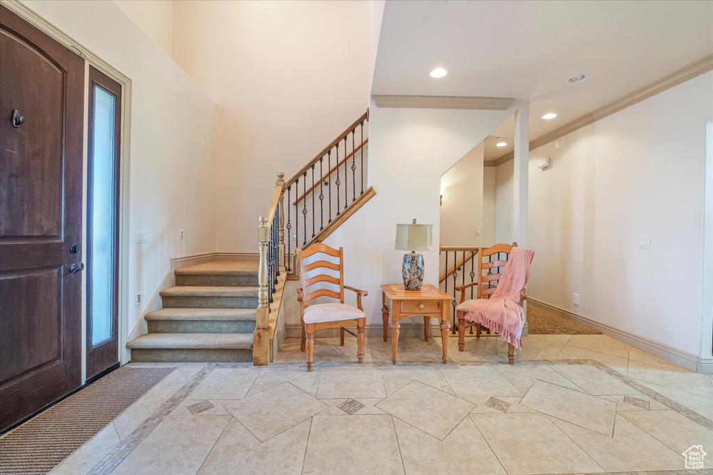 Entryway with inlaid floor details, stairs, baseboards, recessed lighting, and light tile patterned floors