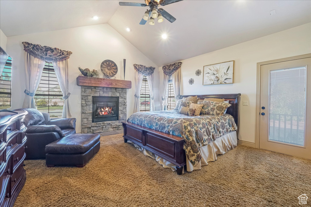 Carpeted bedroom featuring multiple windows, a stone fireplace, recessed lighting, a ceiling fan, and high vaulted ceiling