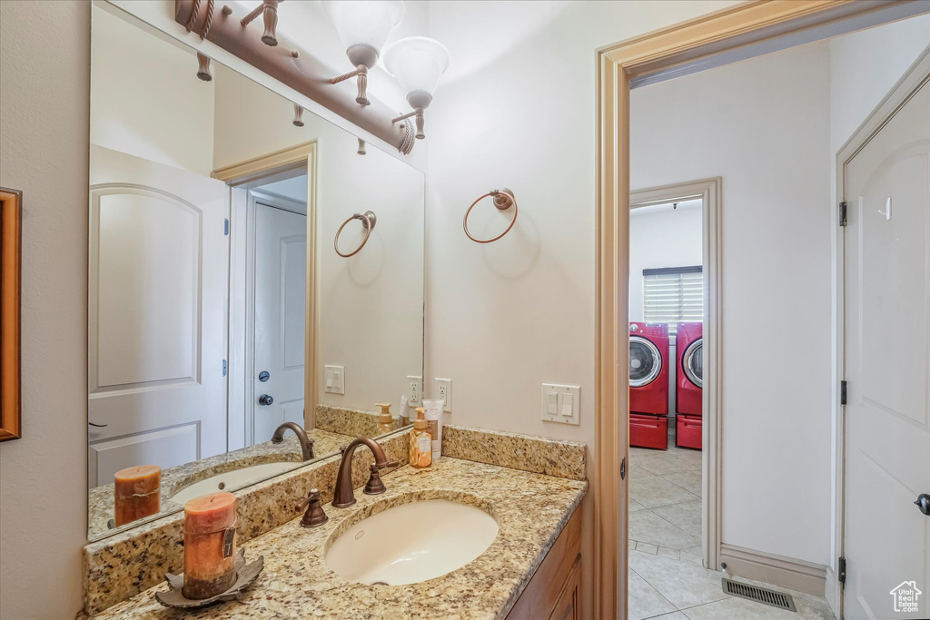 Bathroom featuring independent washer and dryer, tile patterned floors, and vanity
