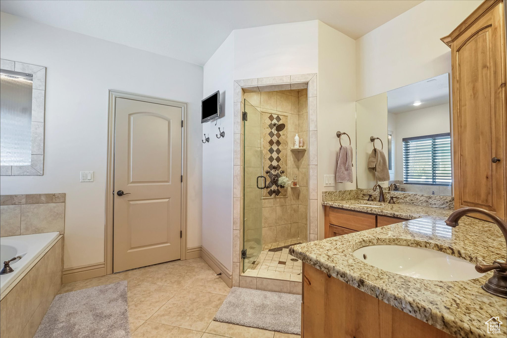 Full bath featuring a stall shower, a bath, vanity, and tile patterned floors