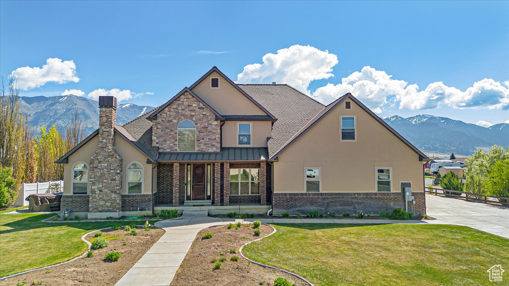 Craftsman house featuring stucco siding, a mountain view, a chimney, and brick siding