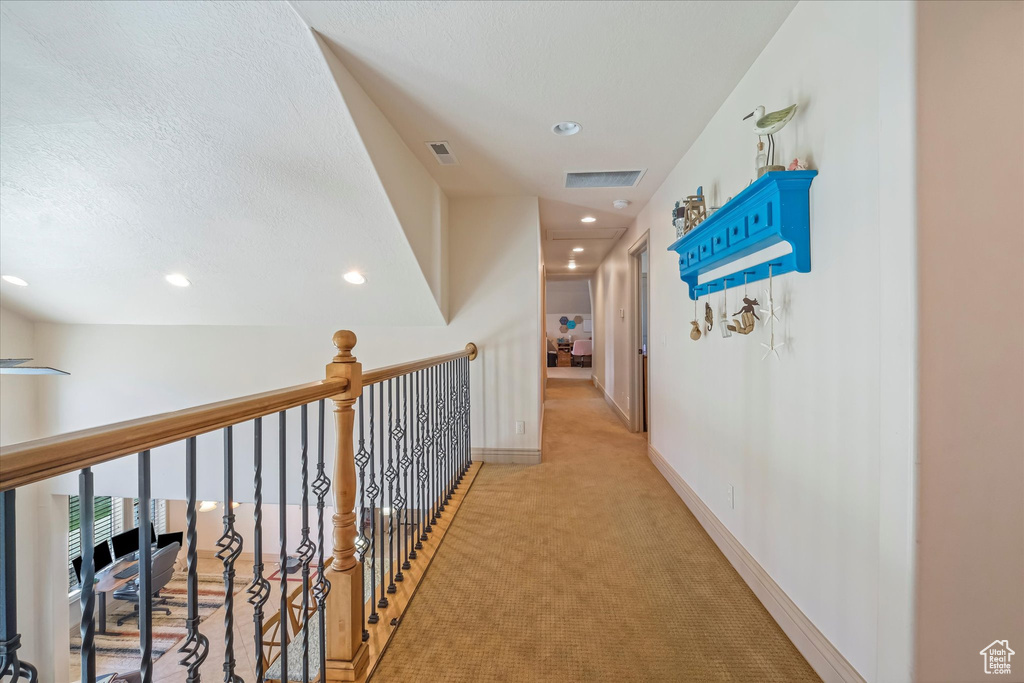 Hallway featuring light colored carpet, recessed lighting, baseboards, and a textured ceiling