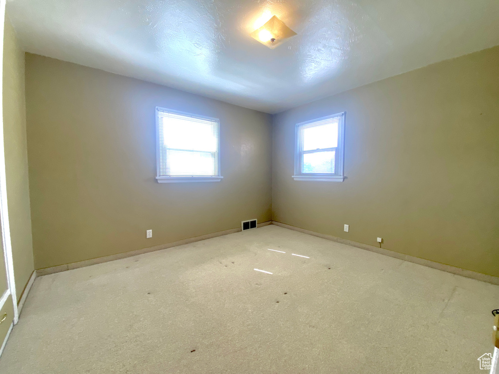 Carpeted empty room featuring baseboards