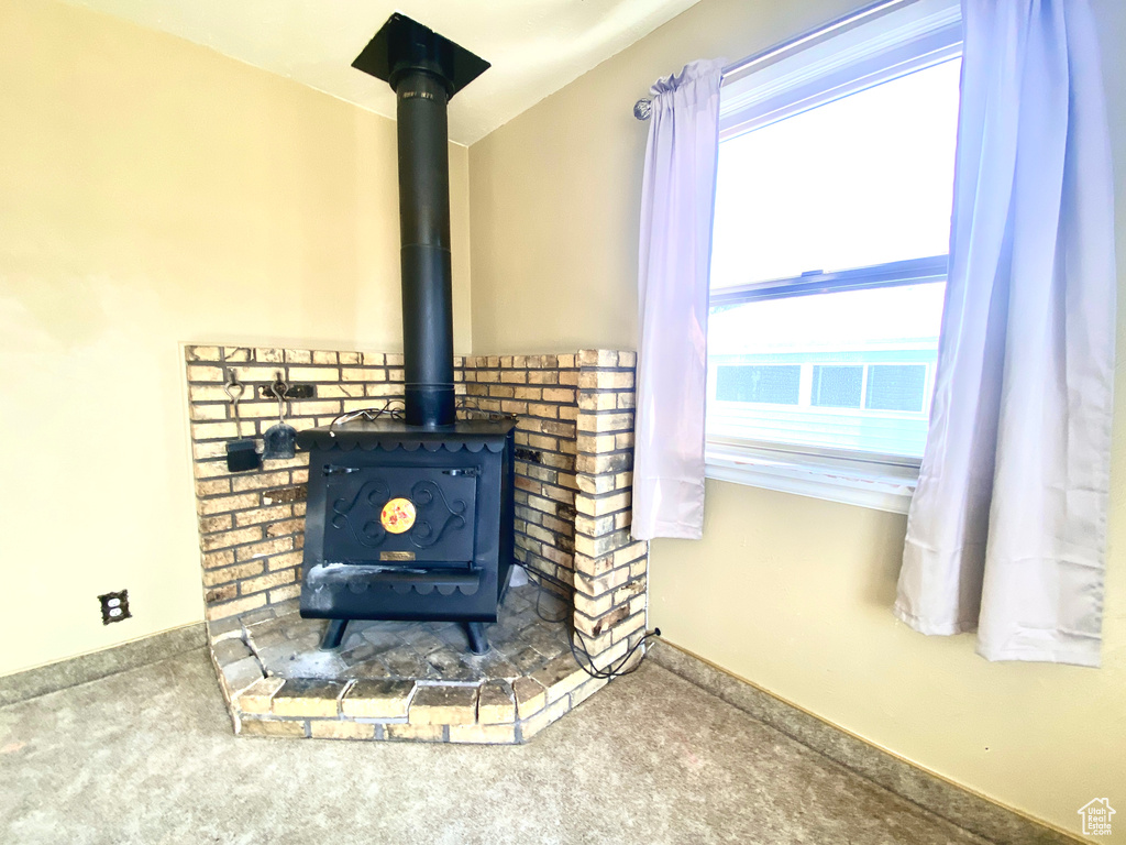 Detailed view of a wood stove, carpet, and baseboards