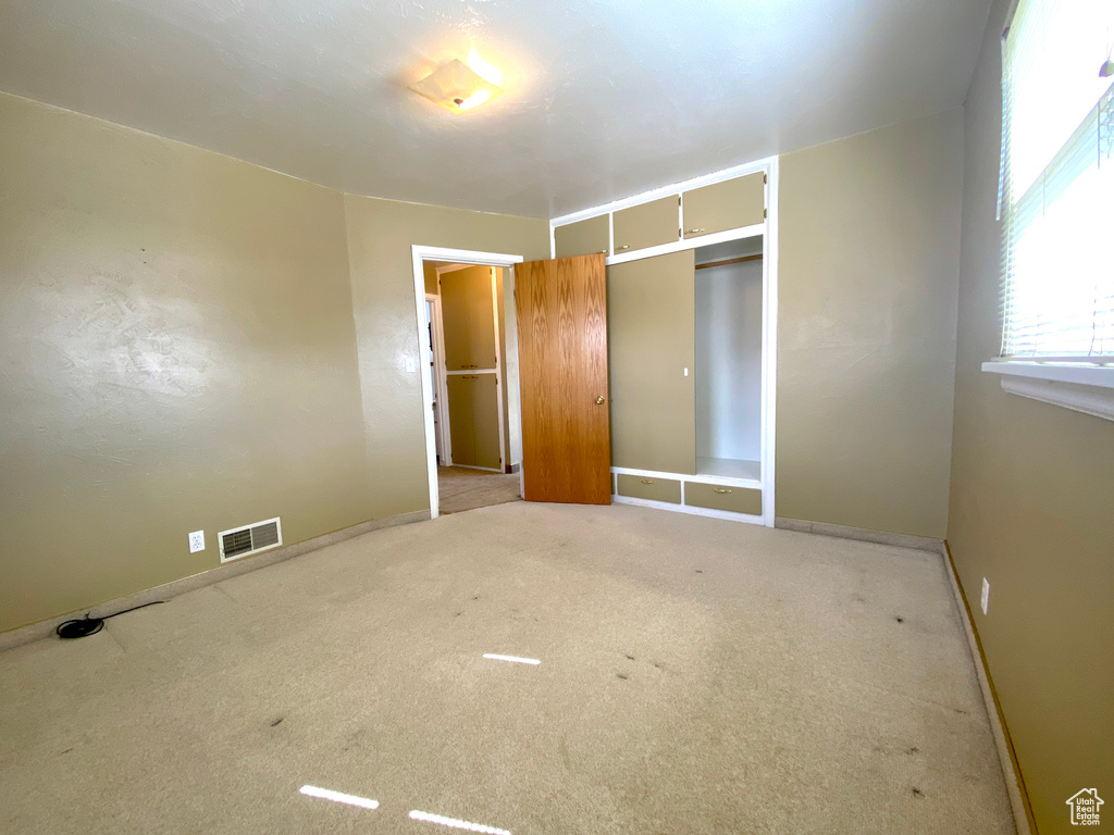 Unfurnished bedroom with carpet, a closet, and baseboards