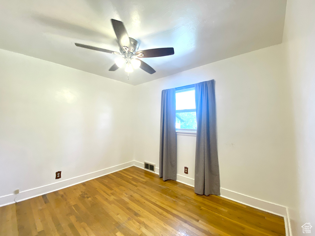 Empty room with baseboards, a ceiling fan, and wood finished floors