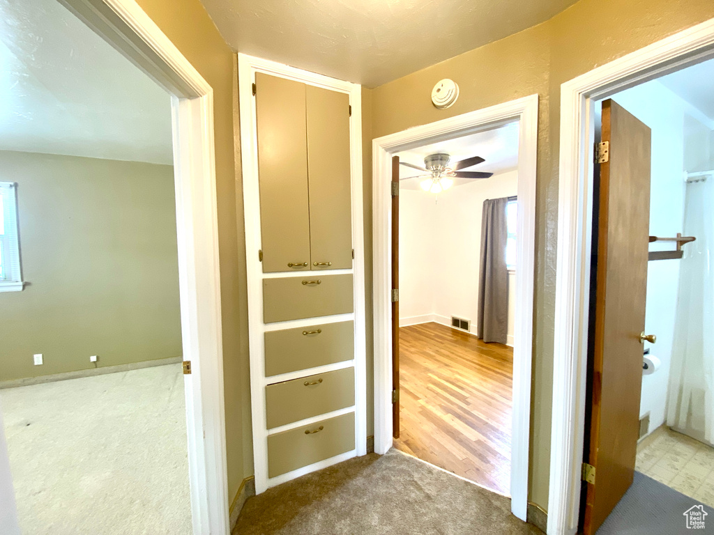 Hallway with carpet floors and baseboards
