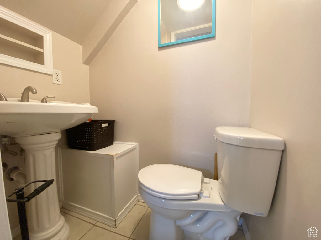 Half bathroom with tile patterned flooring and toilet