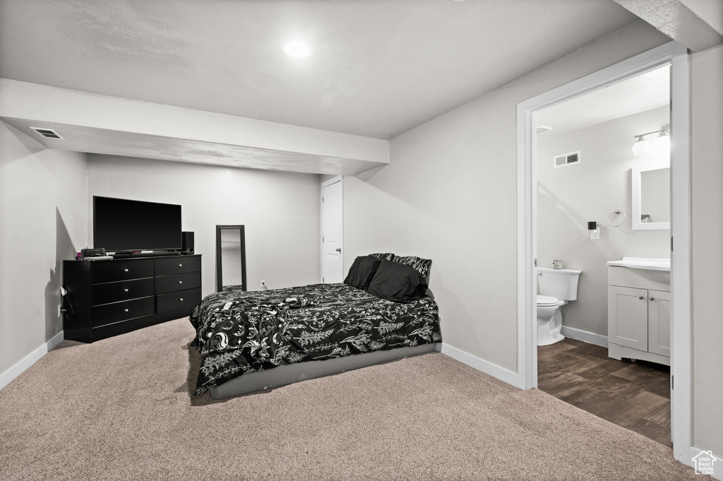 Carpeted bedroom with baseboards and ensuite bath