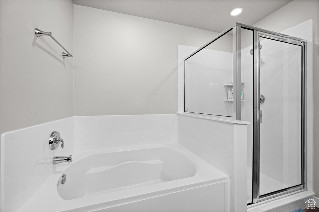 Full bathroom featuring a stall shower, a garden tub, and recessed lighting