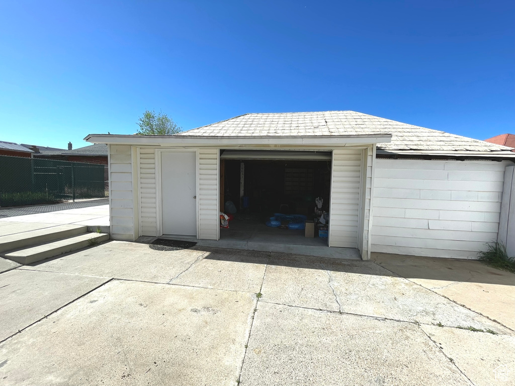 Detached garage featuring fence and concrete driveway