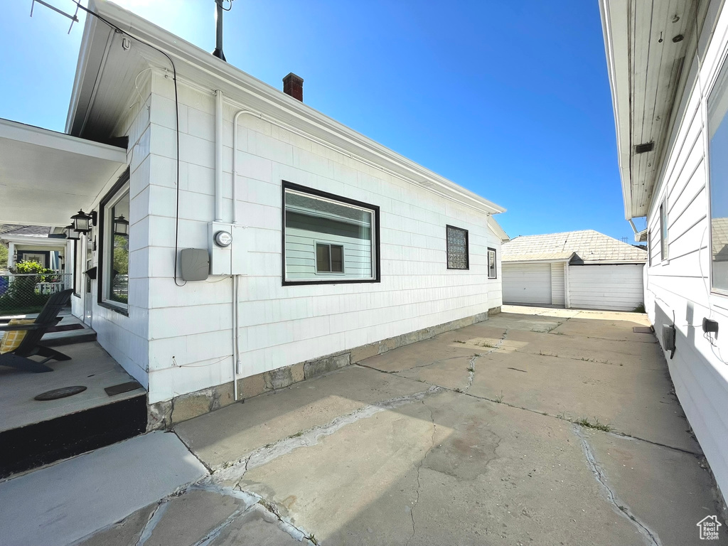 View of home\\\\\\\'s exterior featuring a garage, an outbuilding, and a chimney