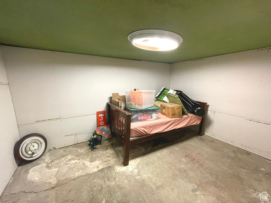 Bedroom with unfinished concrete floors
