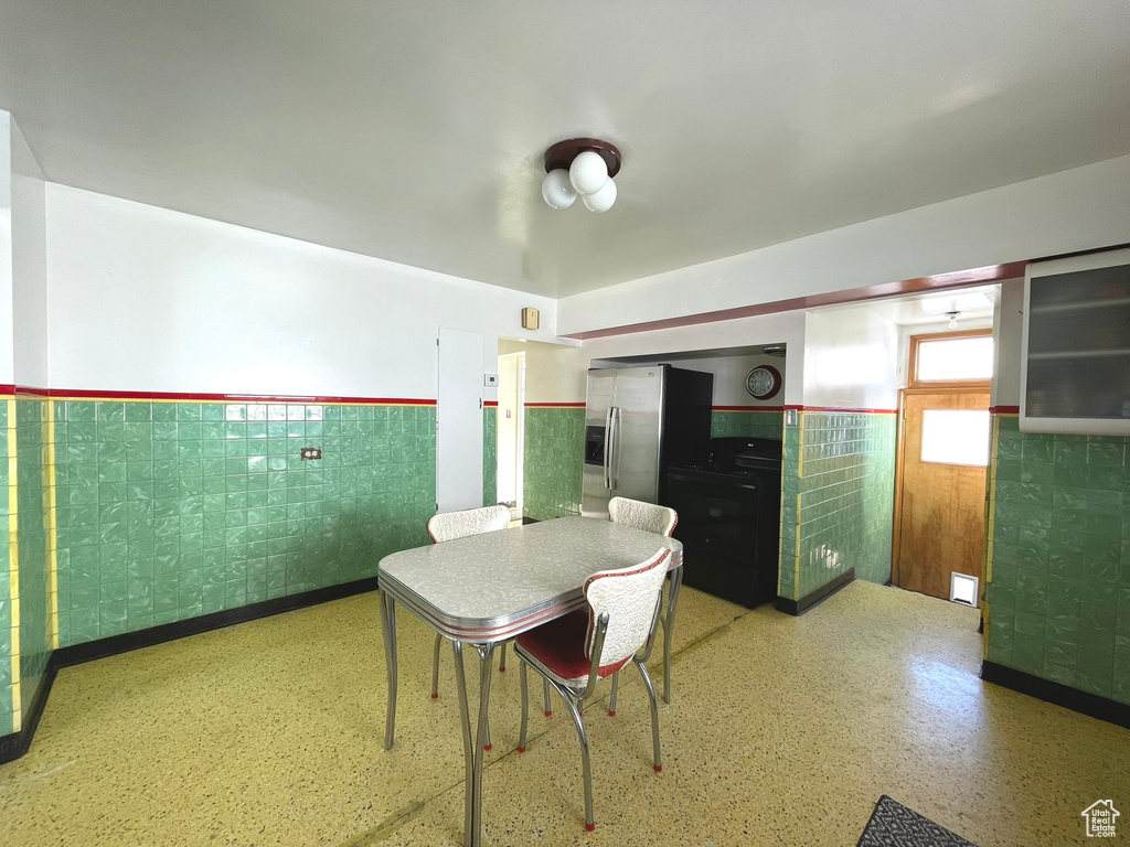 Dining area with wainscoting and tile walls